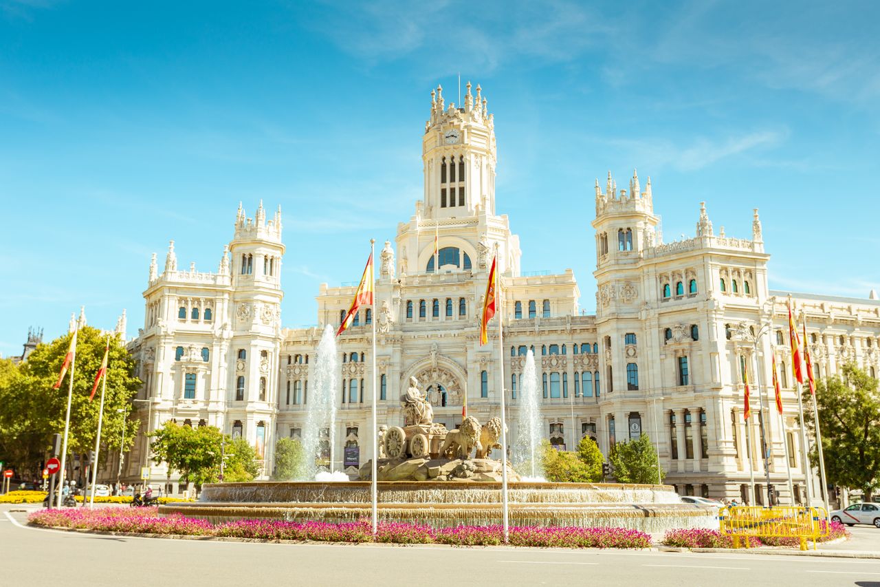 about-01 Iconic view of the Cibeles Fountain and Palace, a landmark in central Madrid, Spain, under clear skies.