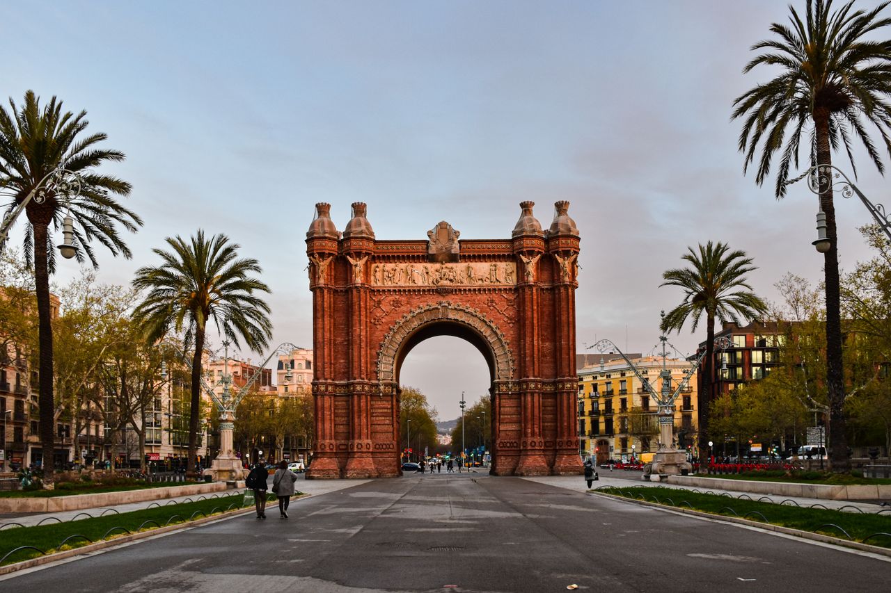 Stunning view of the Arc de Triomf in Barcelona, featuring clear blue skies and palm trees.