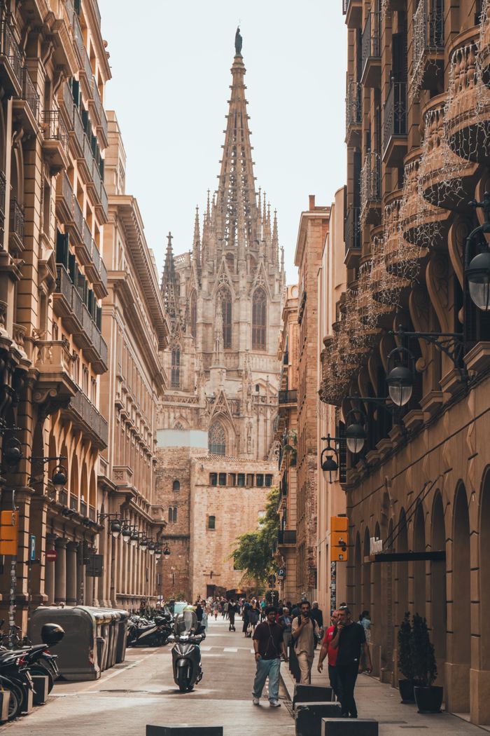 hero-img-02 Beautiful view of Barcelona's Gothic Cathedral surrounded by historic city streets.