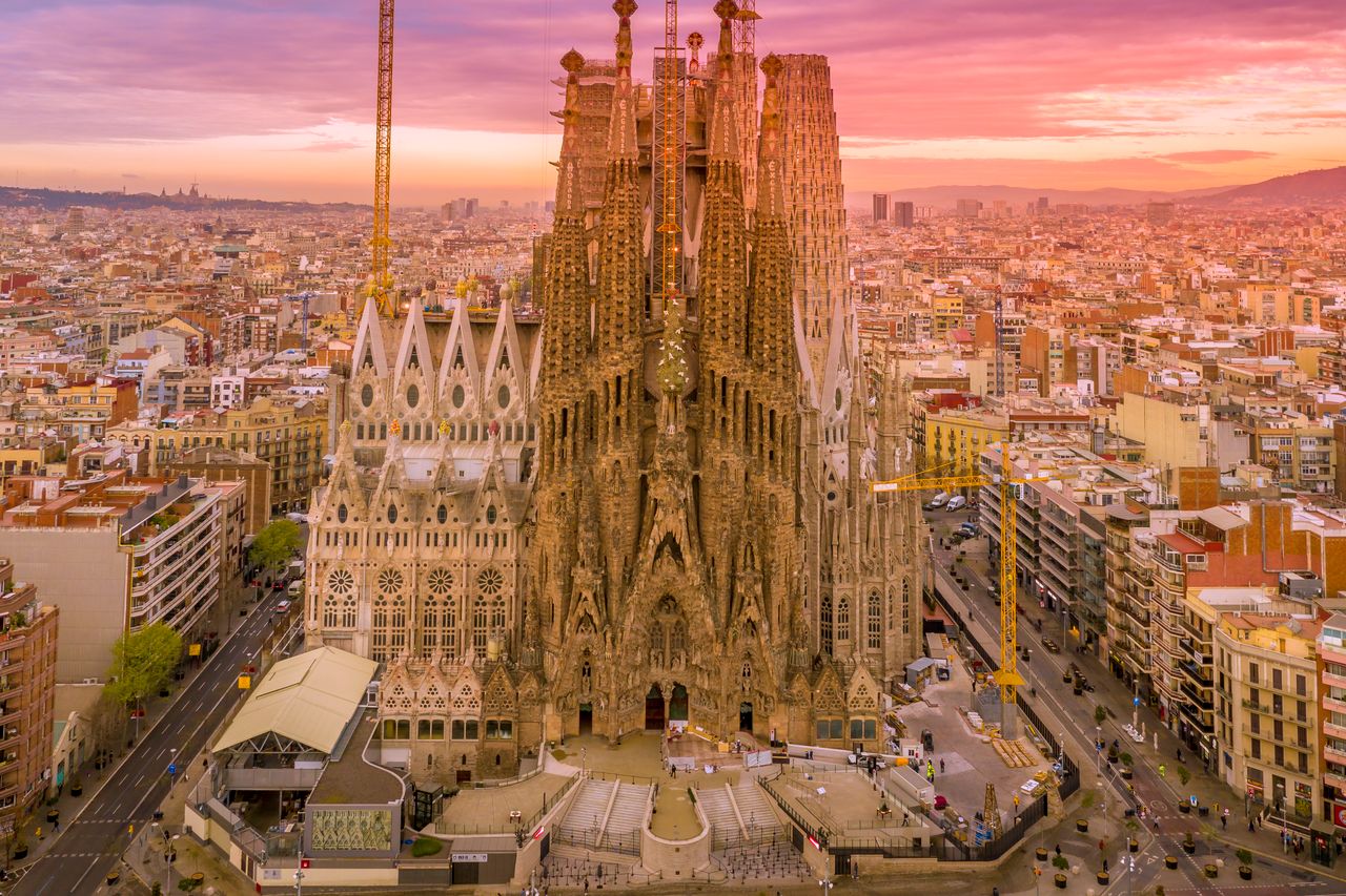 services-02 A breathtaking aerial capture of the Sagrada Familia in Barcelona during a vibrant sunset.